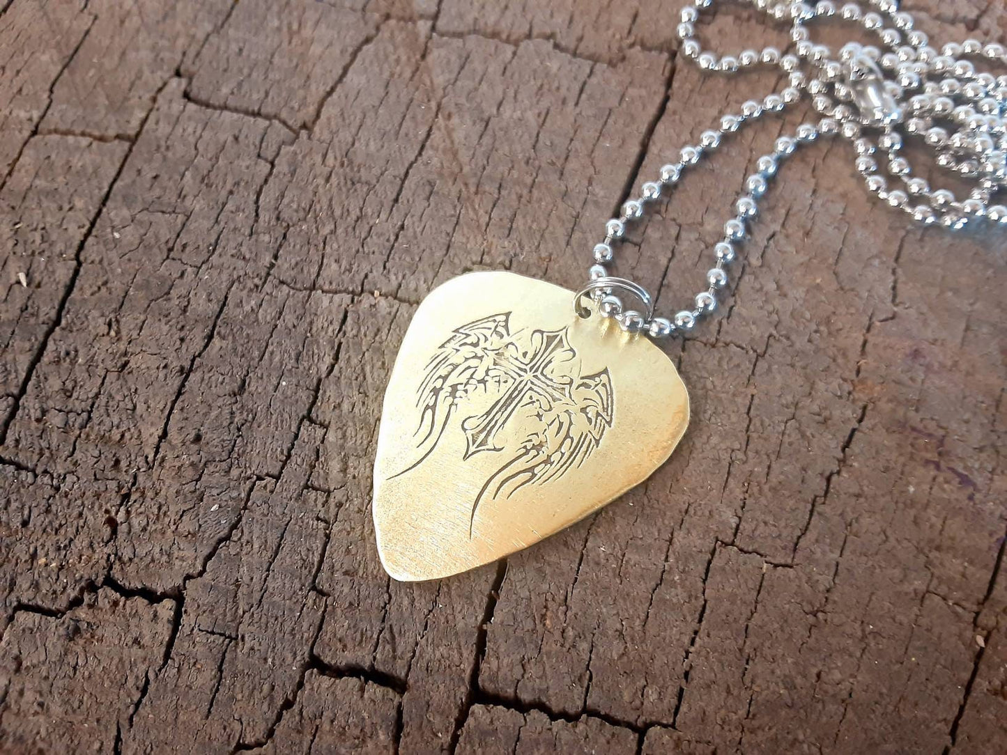 Winged cross on brass guitar pick necklace