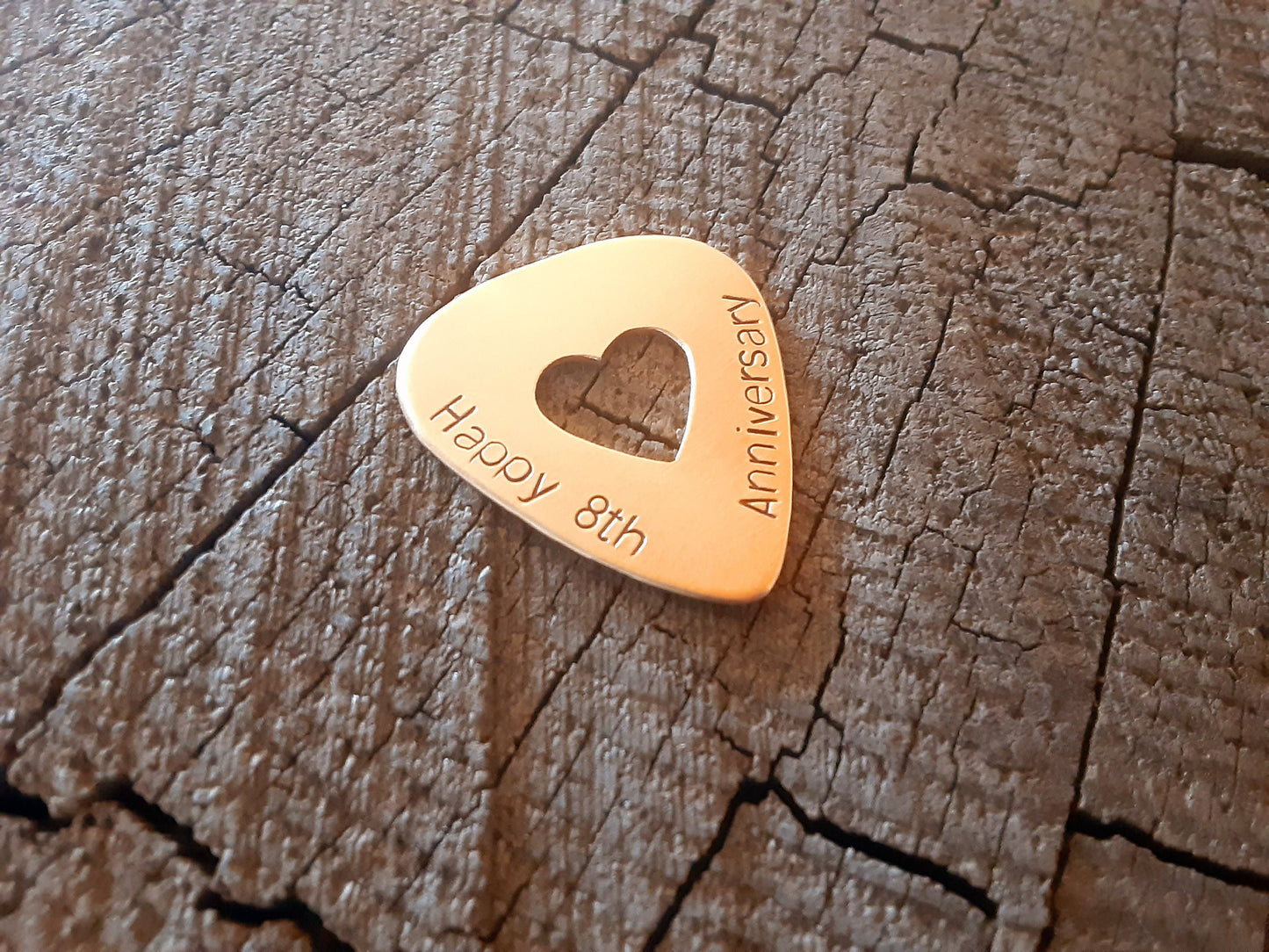 Guitar pick in bronze with heart