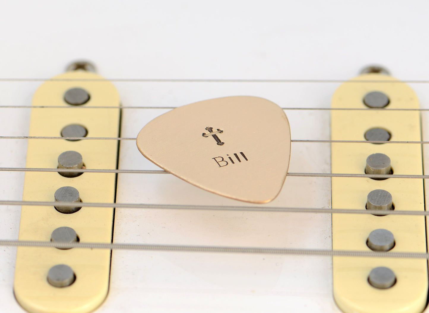 Customized name on a bronze guitar pick