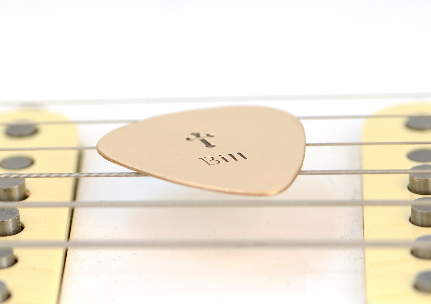 Customized name on a bronze guitar pick