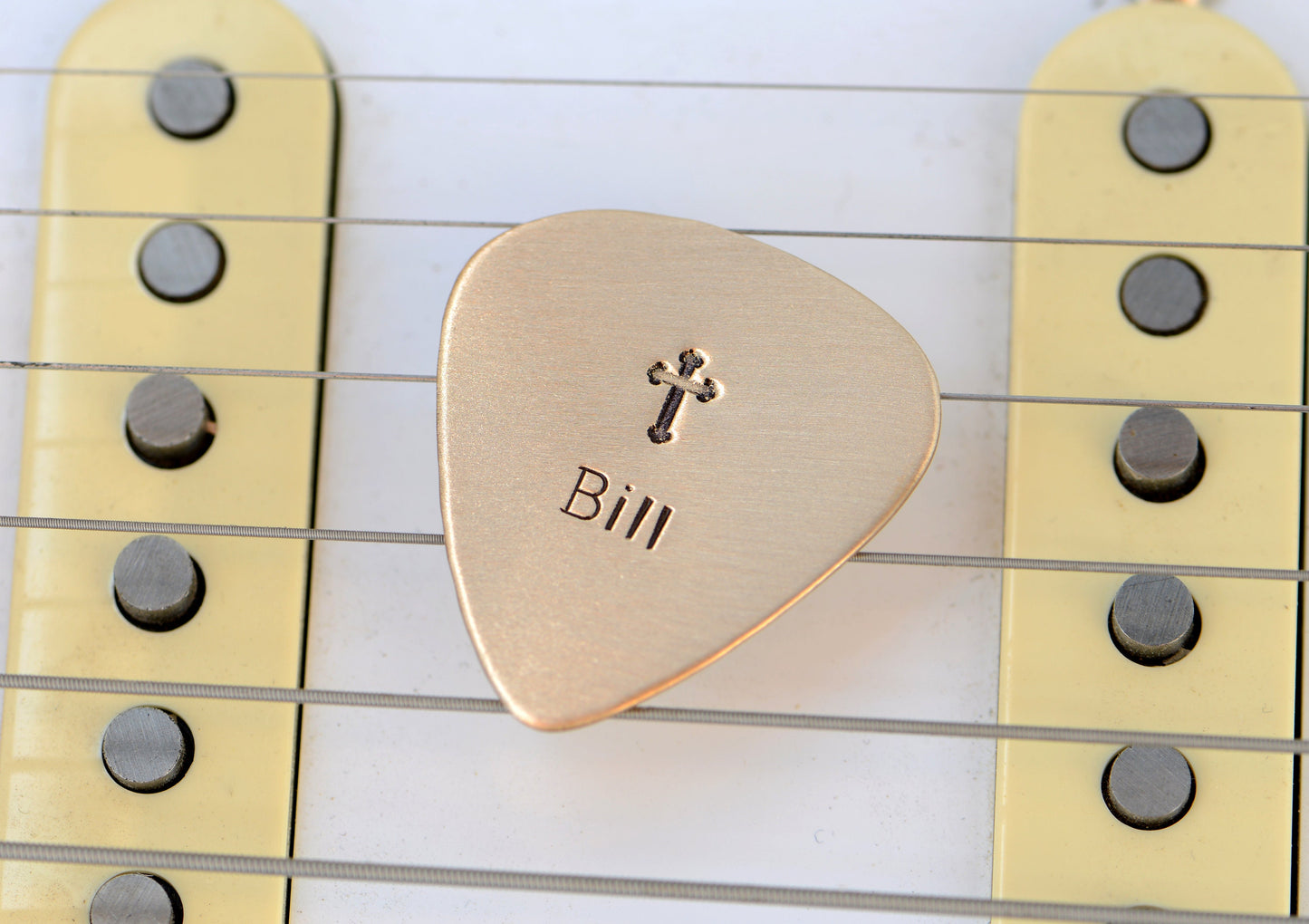 Customized name on a bronze guitar pick