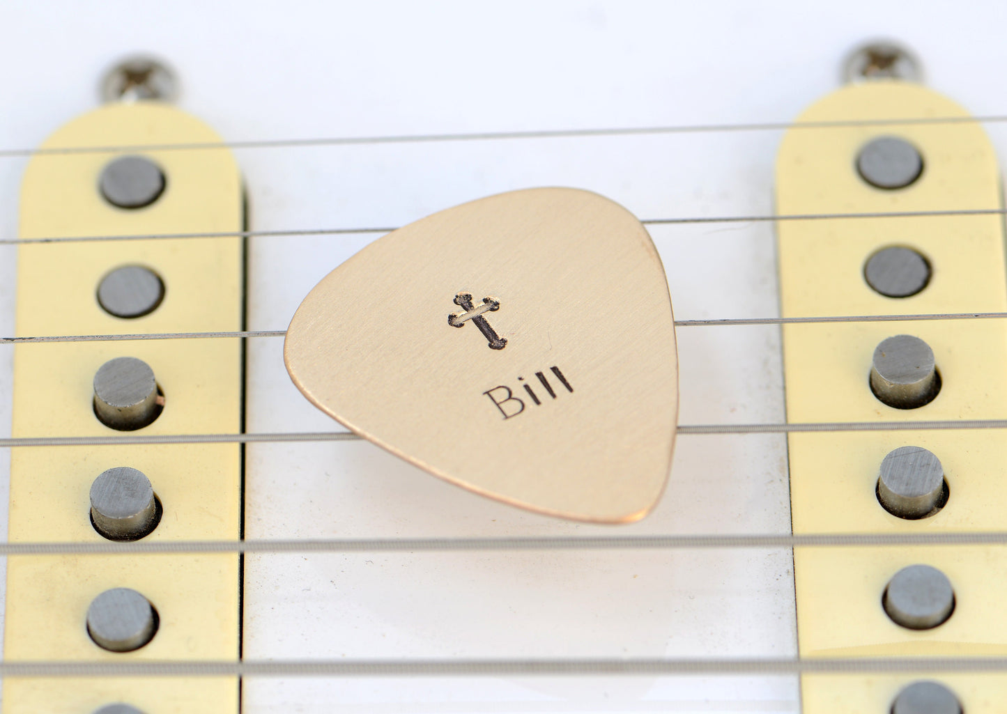 Customized name on a bronze guitar pick