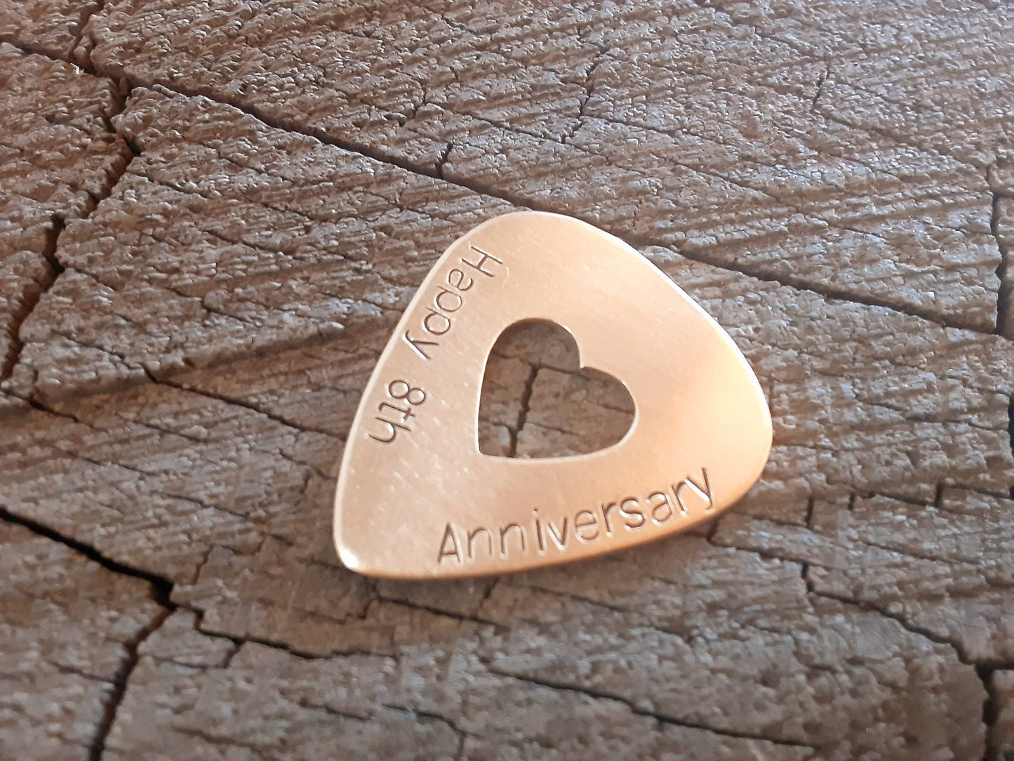 Anniversary bronze guitar pick with cutout heart