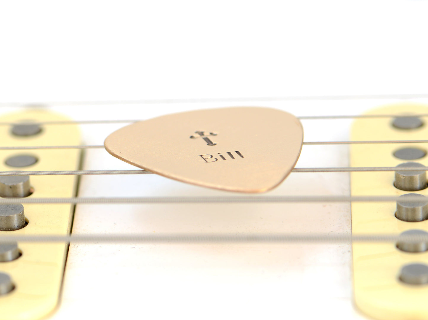 Customized name on a bronze guitar pick