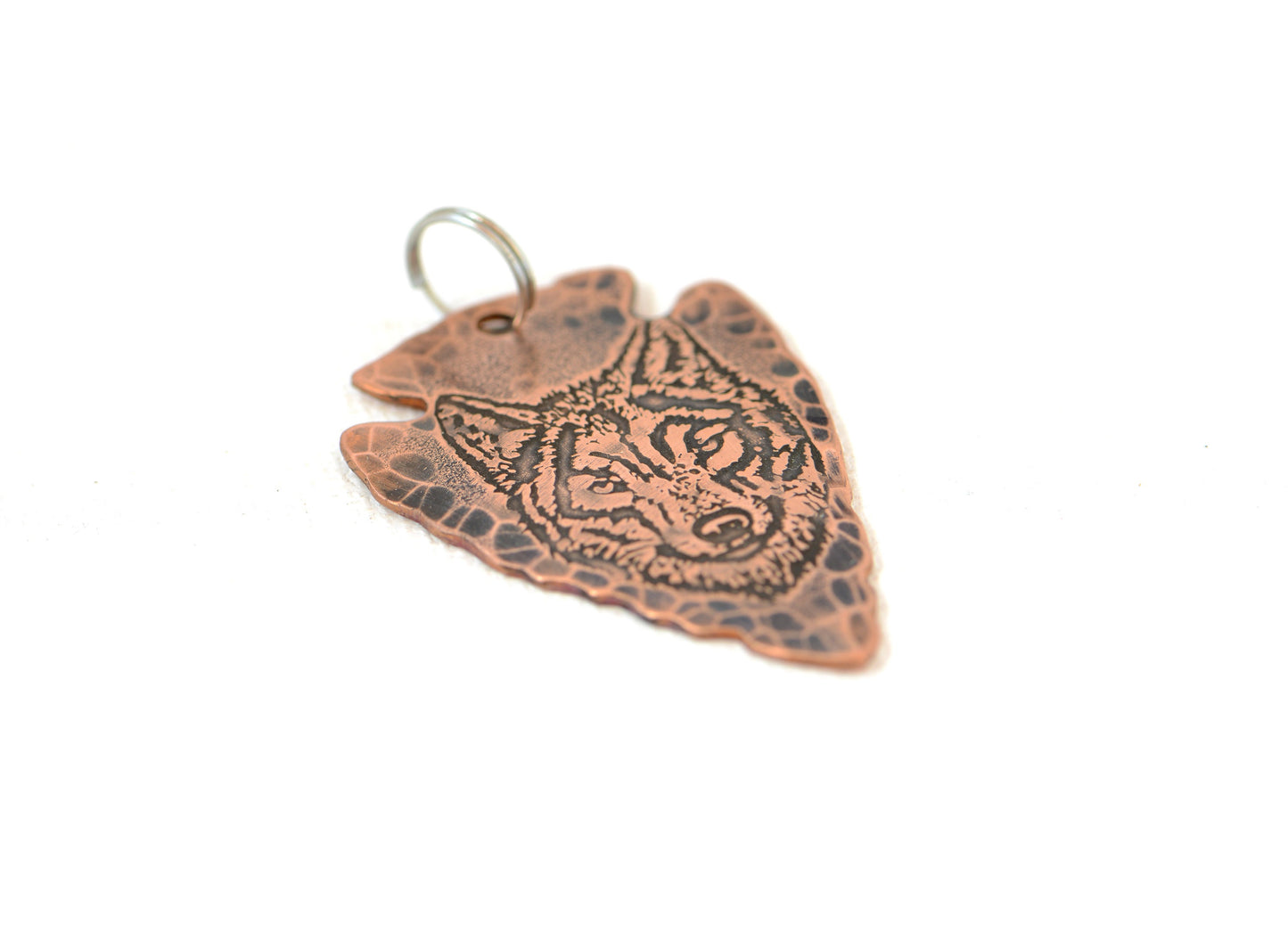 Rustic copper arrowhead pendant with wolf design