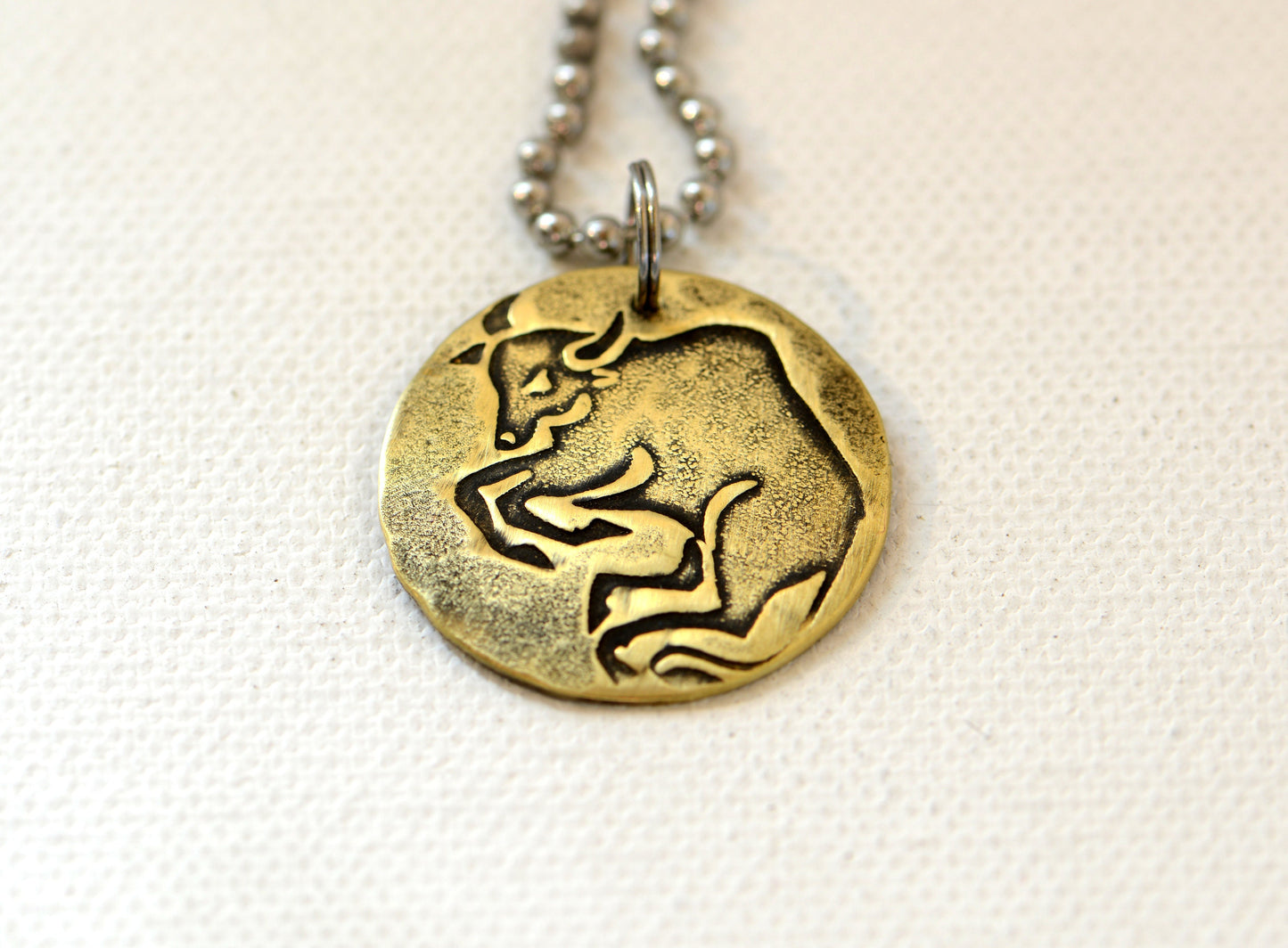 Taurus Zodiac on a brass disc necklace