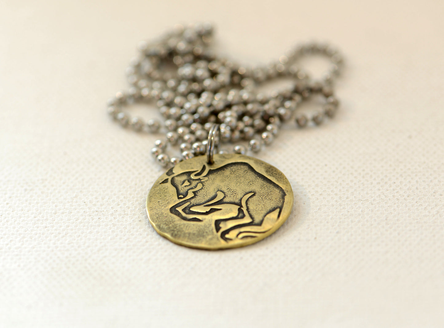 Taurus Zodiac on a brass disc necklace