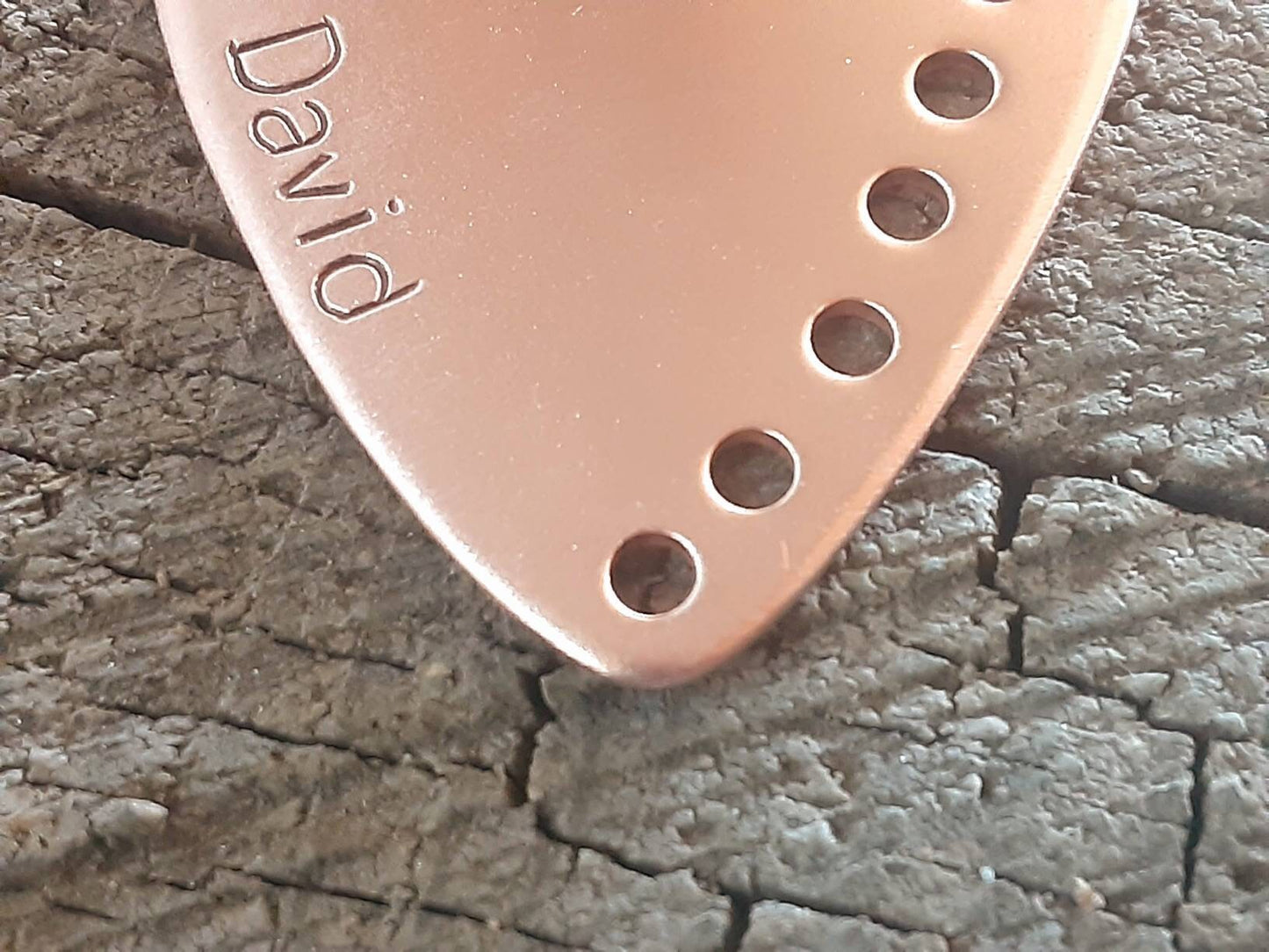Custom copper guitar pick with holes along the edge and your name