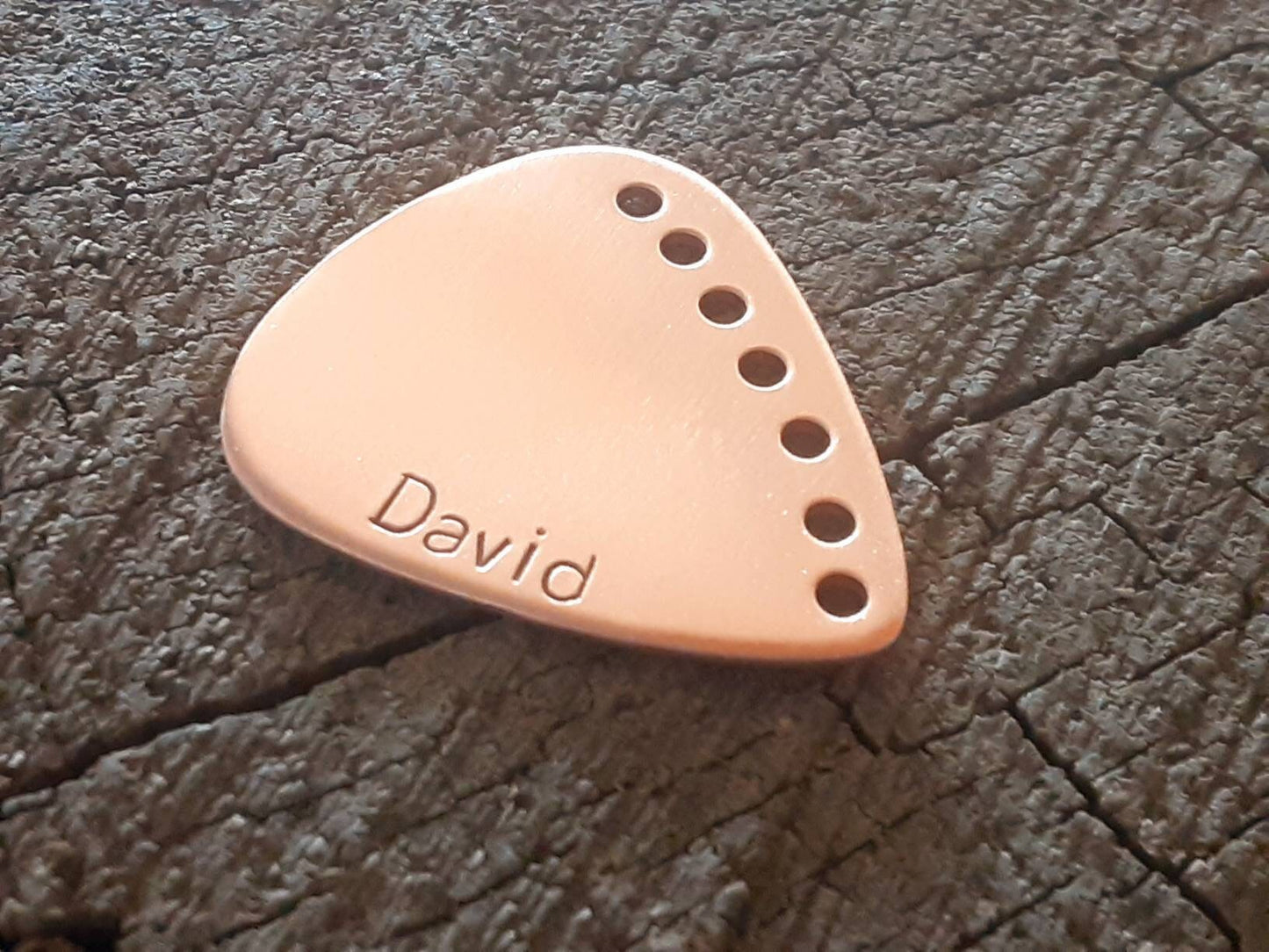 Custom copper guitar pick with holes along the edge and your name