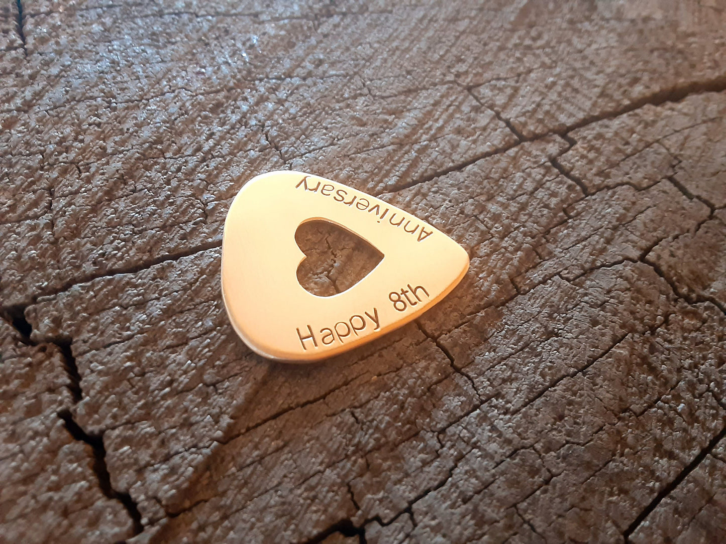 Anniversary bronze guitar pick with cutout heart