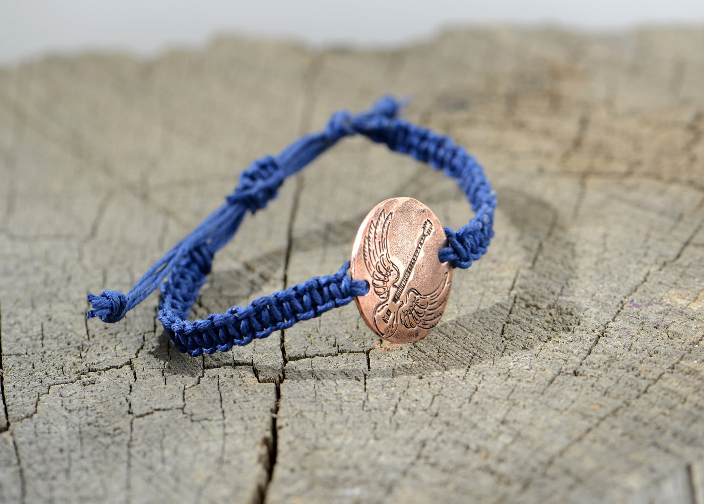 Winged guitar on copper tag with blue hemp bracelet