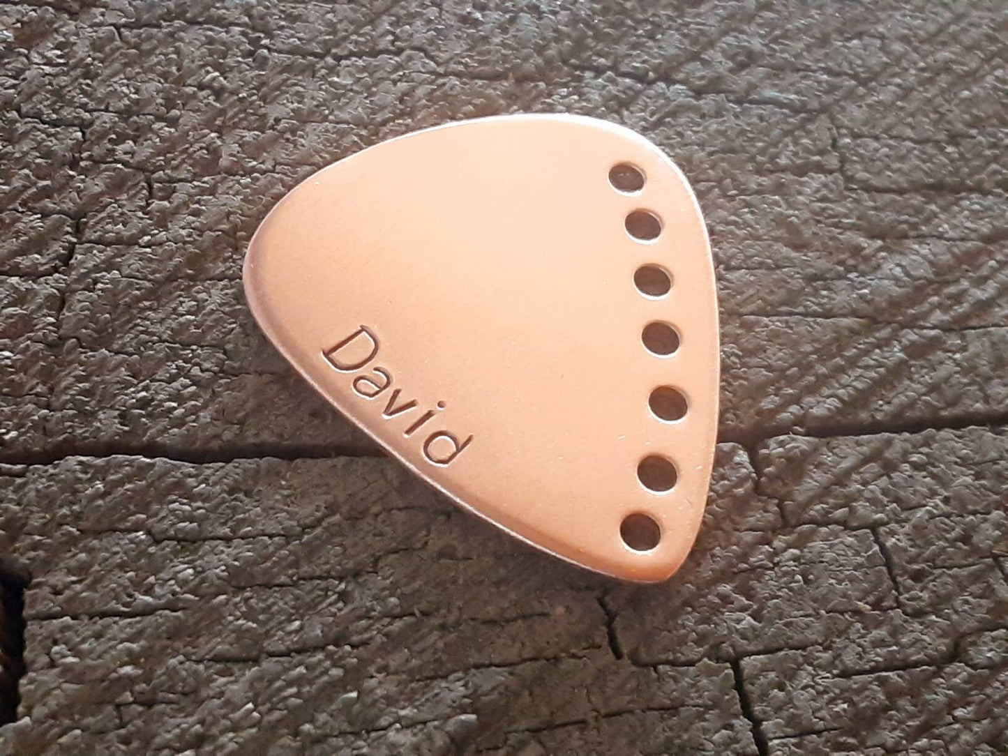 Custom copper guitar pick with holes along the edge and your name