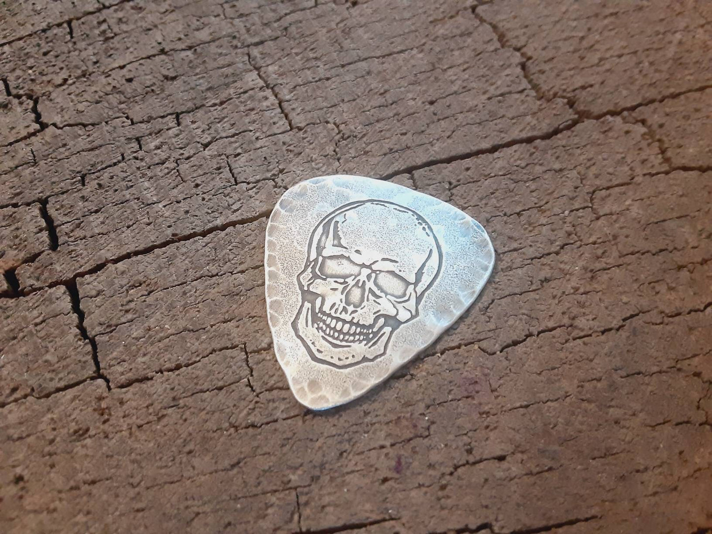 Sterling silver guitar pick with skull and hammered edges