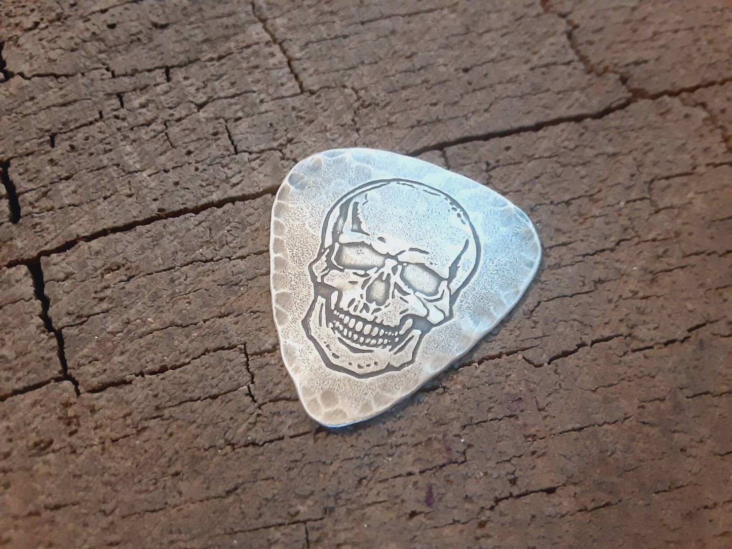 Sterling silver guitar pick with skull and hammered edges