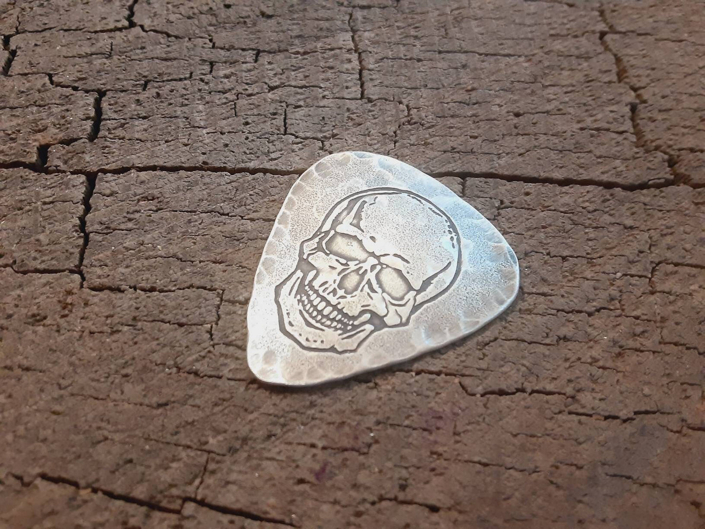 Sterling silver guitar pick with skull and hammered edges