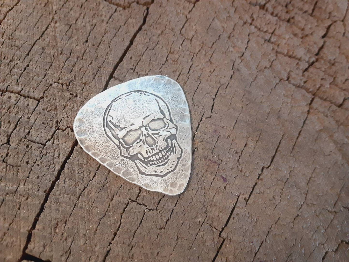 Sterling silver guitar pick with skull and hammered edges