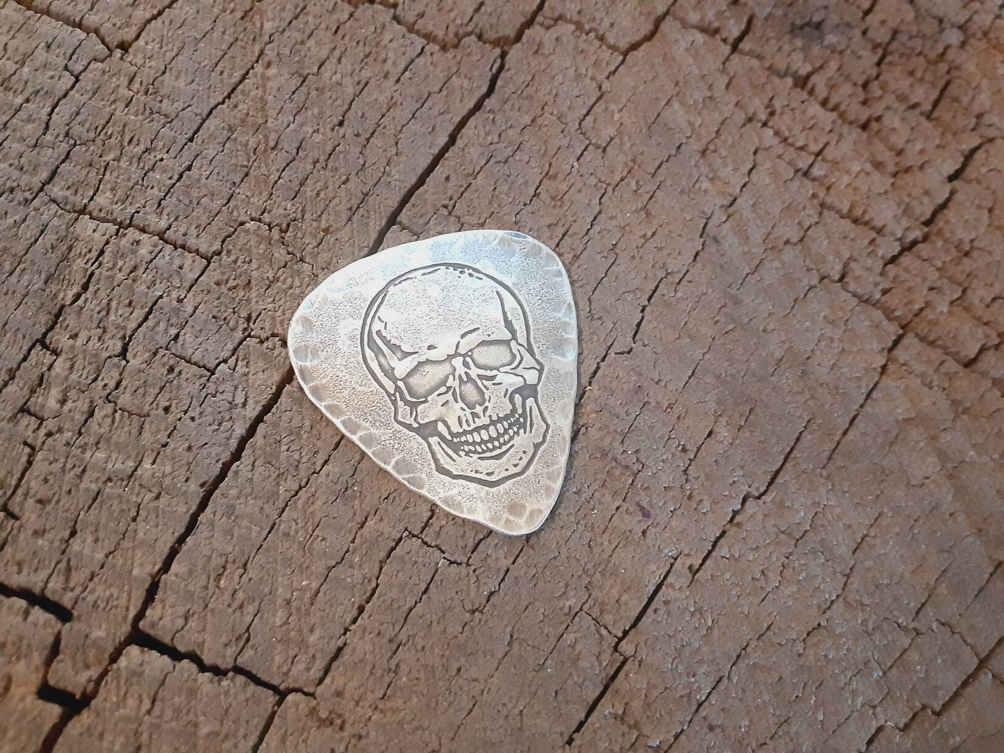 Sterling silver guitar pick with skull and hammered edges