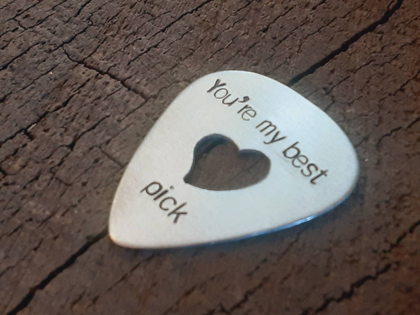 Playable aluminum guitar pick with heart cut out to improve grip