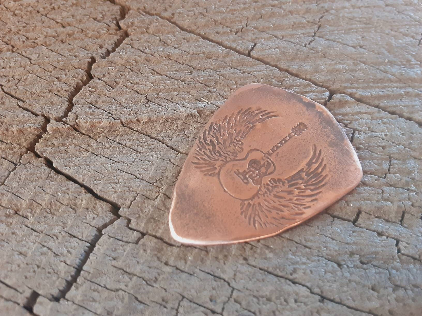 Copper guitar pick in shield shape