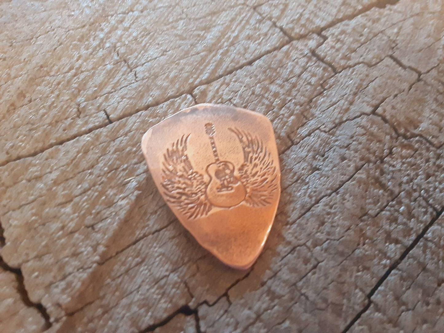 Copper guitar pick in shield shape