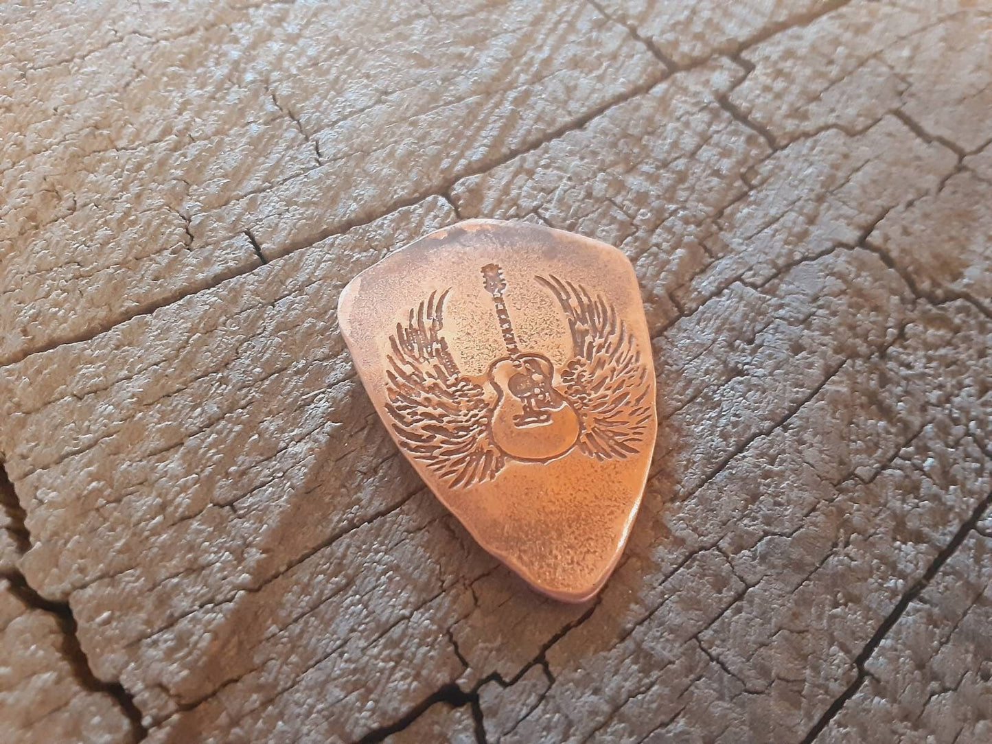 Copper guitar pick in shield shape