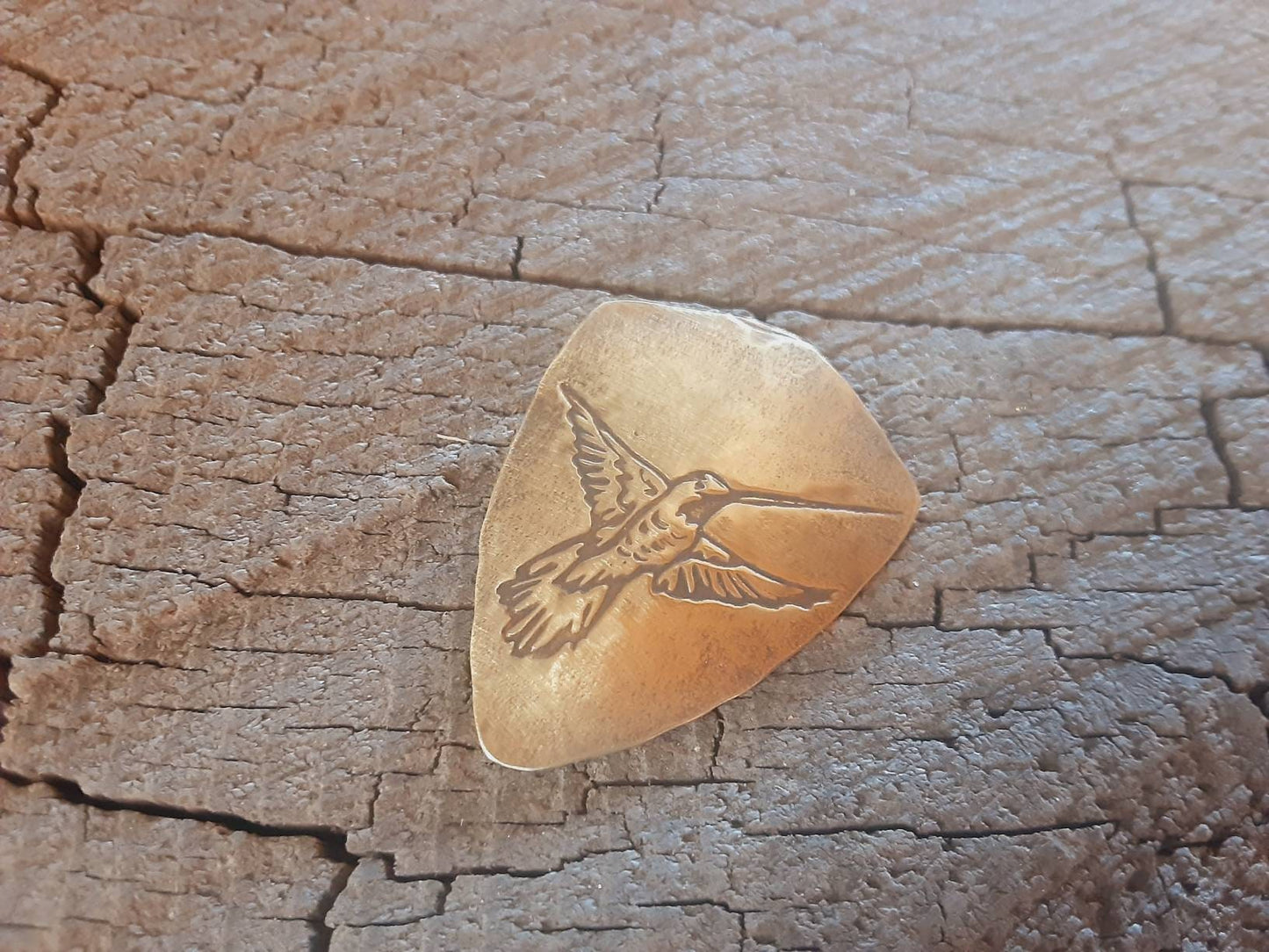Hummingbird on bronze shield shaped guitar pick