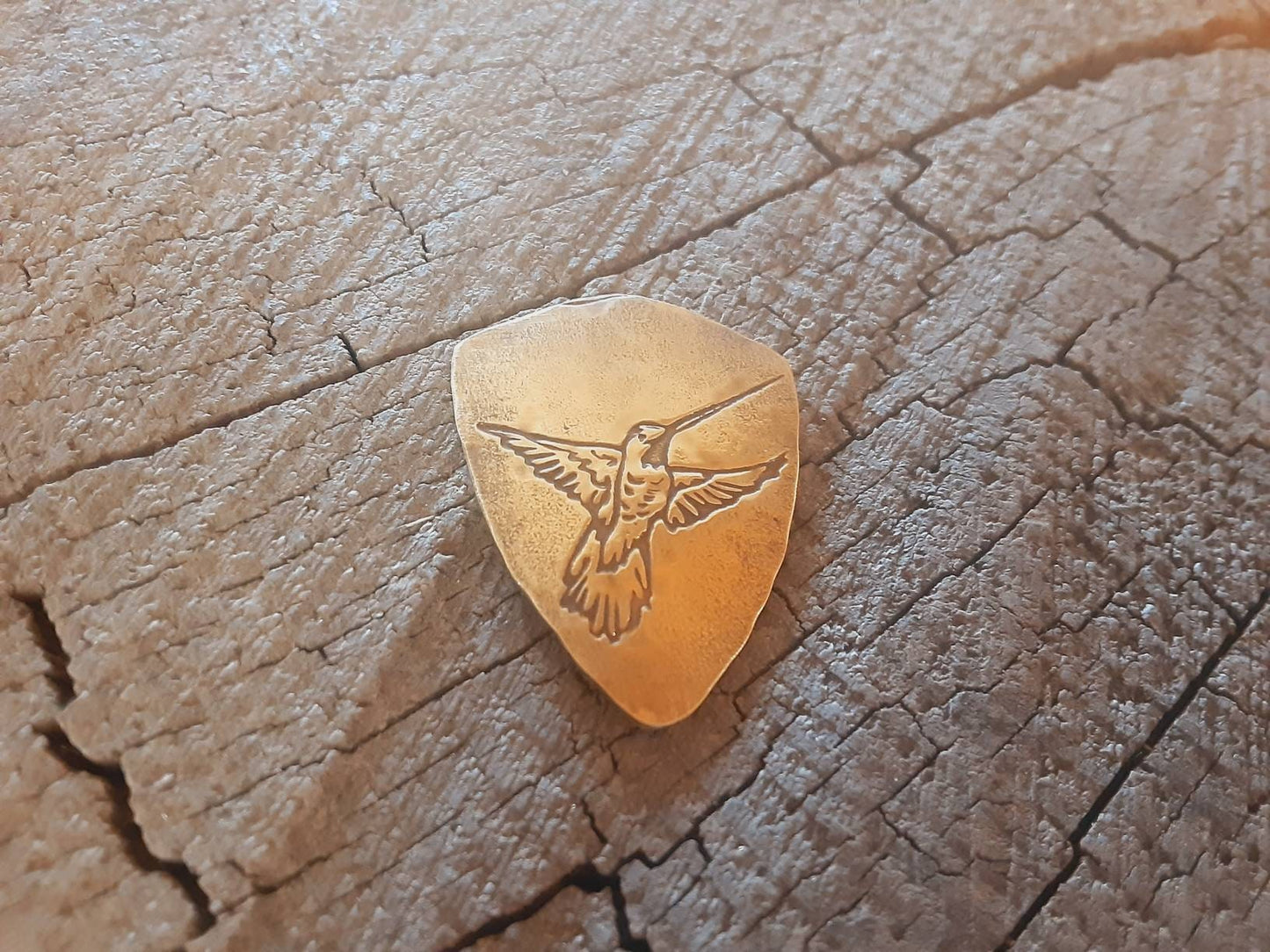 Hummingbird on bronze shield shaped guitar pick