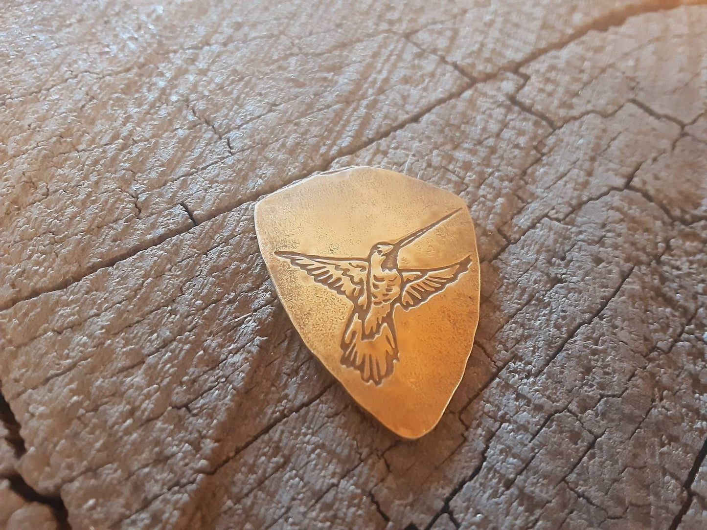 Hummingbird on bronze shield shaped guitar pick
