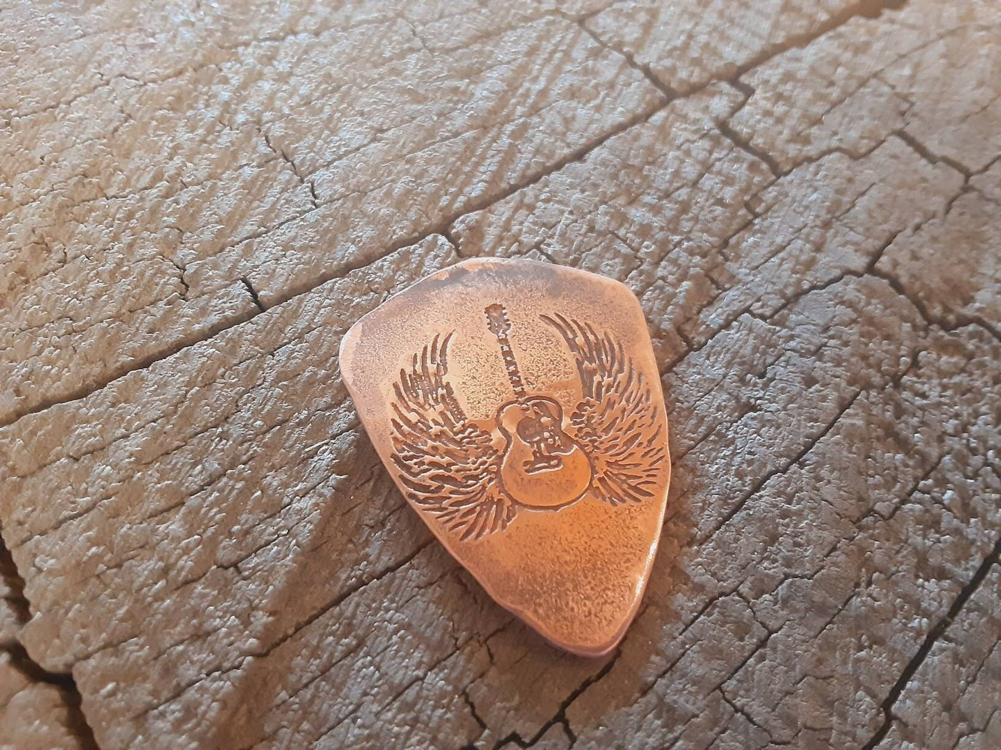 Copper guitar pick in shield shape