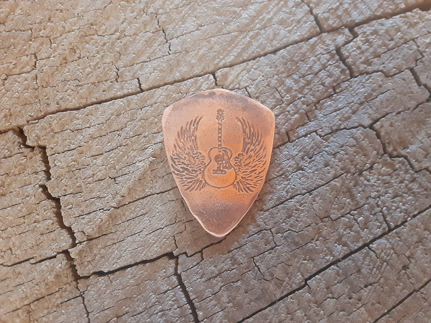 Copper guitar pick in shield shape