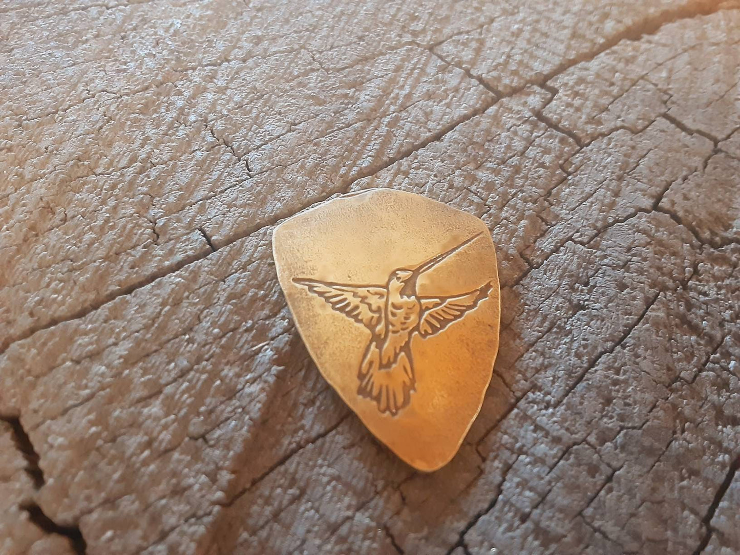 Hummingbird on bronze shield shaped guitar pick