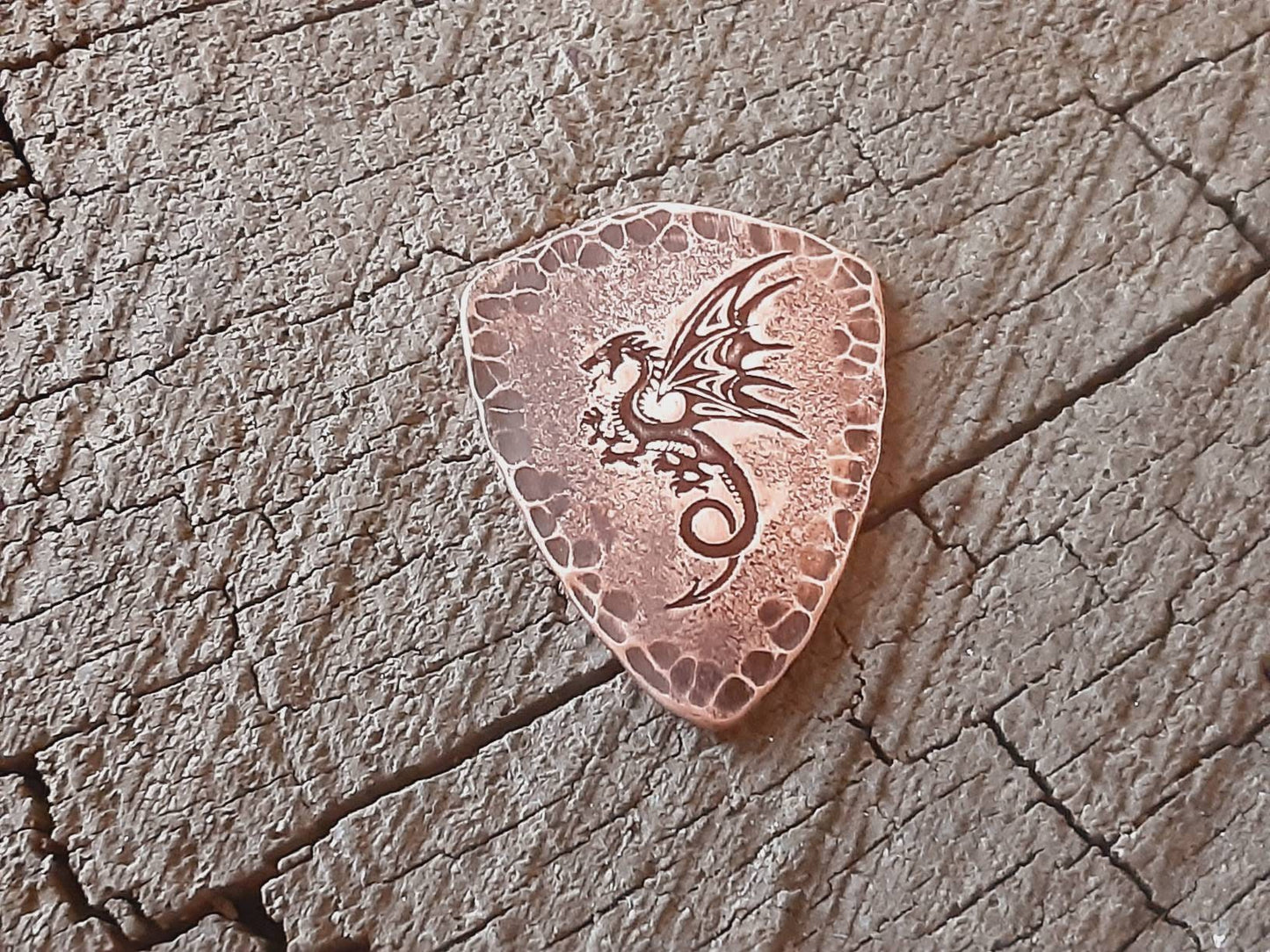Shield style guitar pick in copper with a dragon design