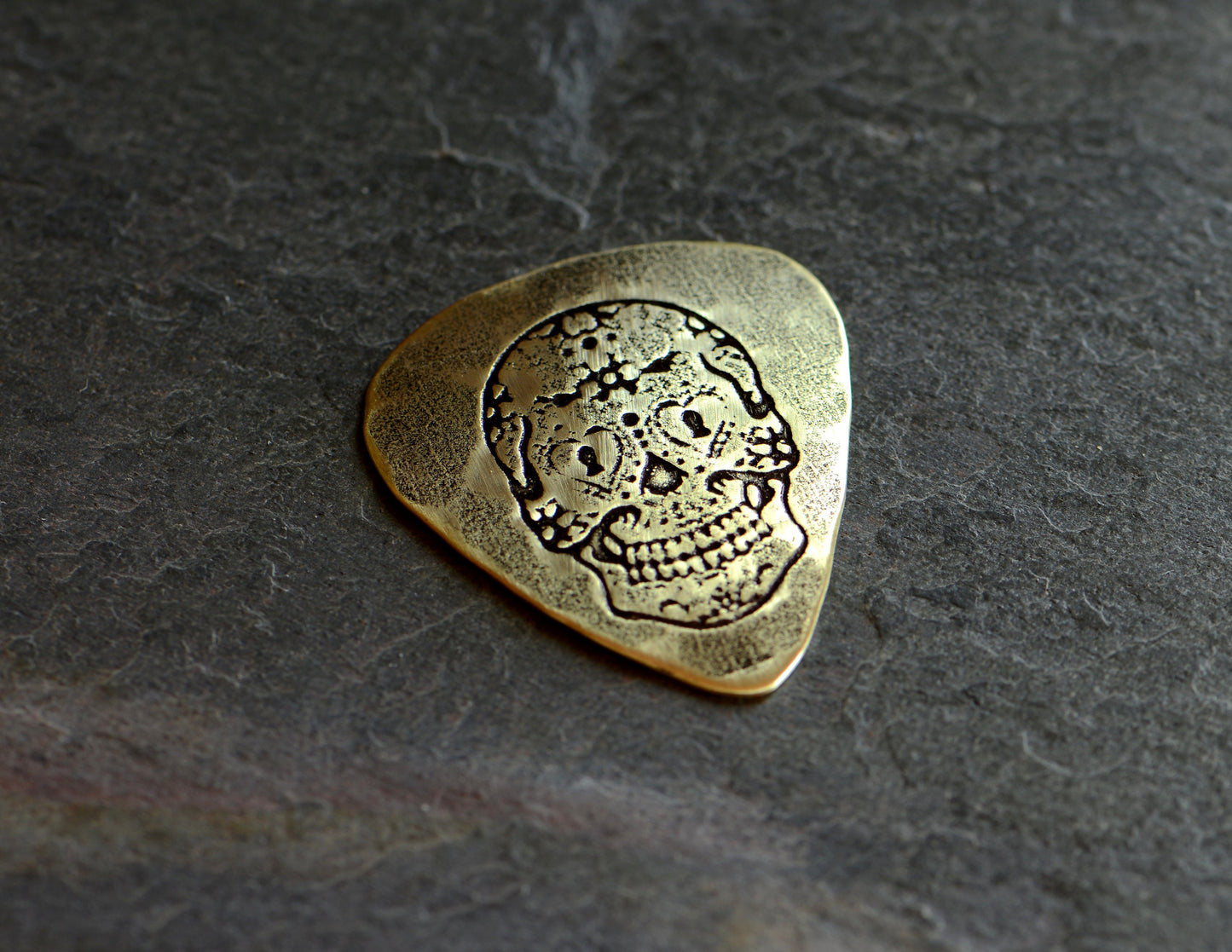 Playable brass guitar pick with sugar skull