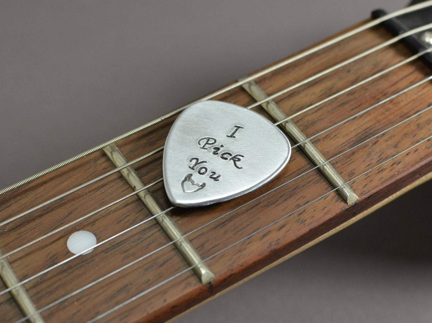 Medium sized guitar pick with I pick you in aluminum