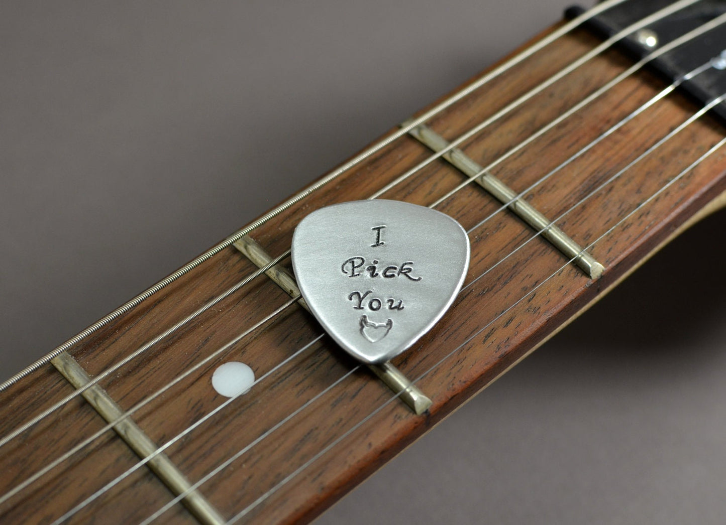 Medium sized guitar pick with I pick you in aluminum