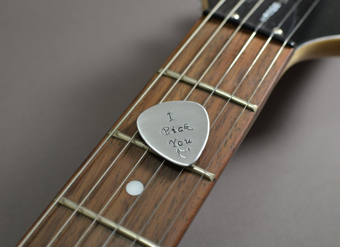 Medium sized guitar pick with I pick you in aluminum