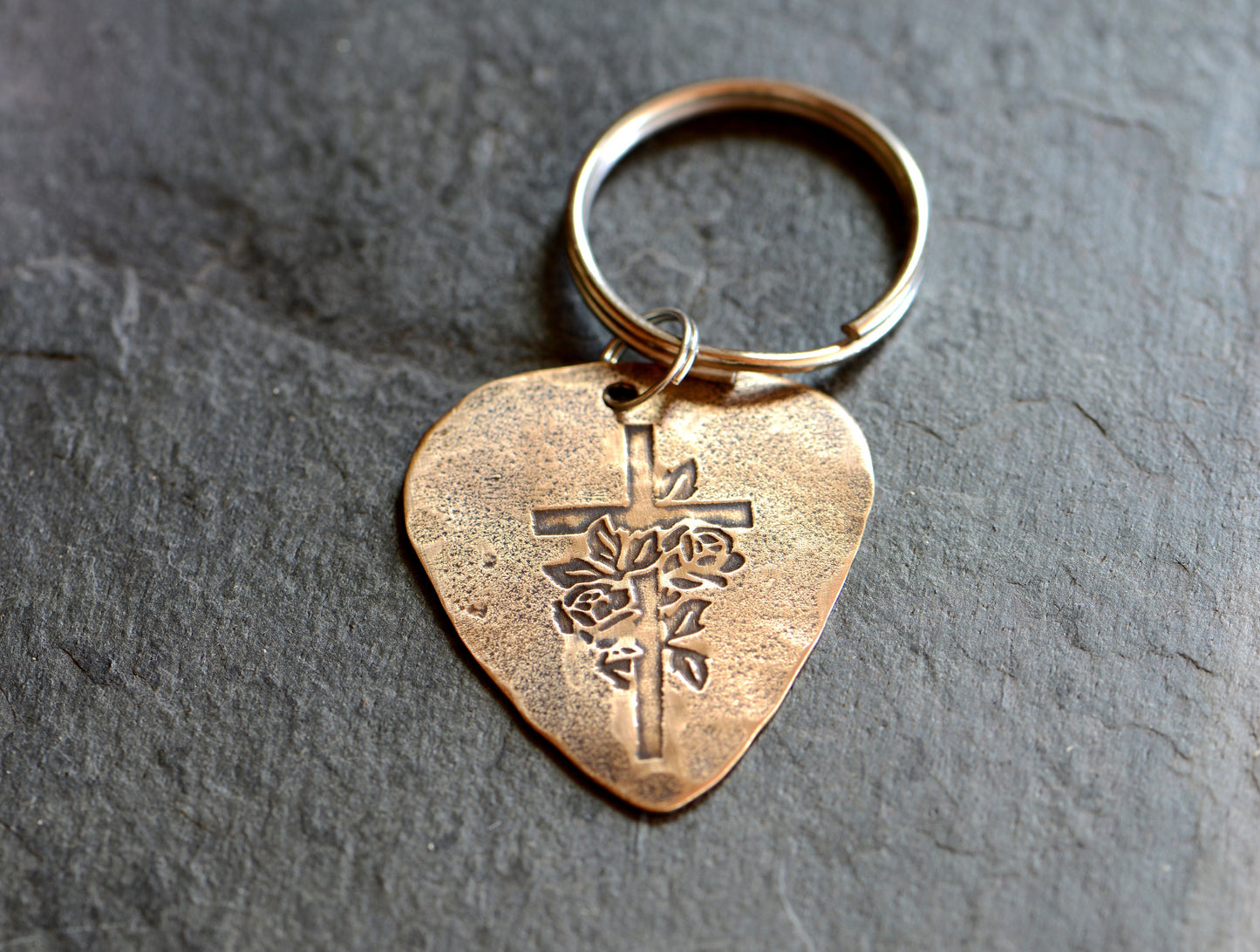 Roses and cross design on bronze guitar pick keychain