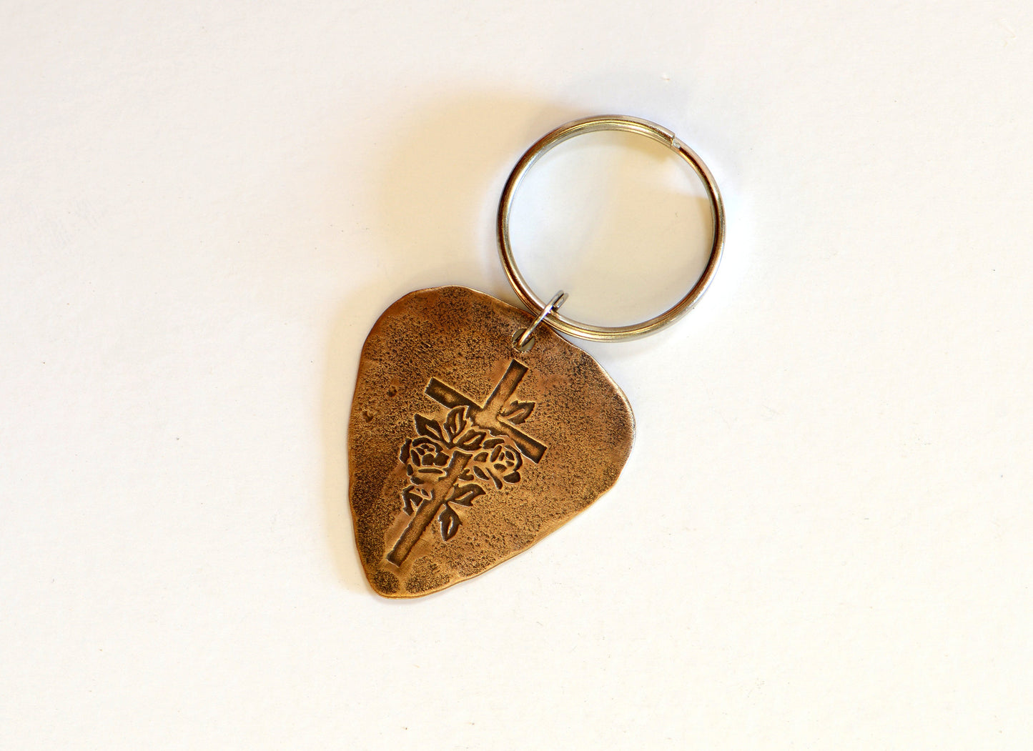 Roses and cross design on bronze guitar pick keychain