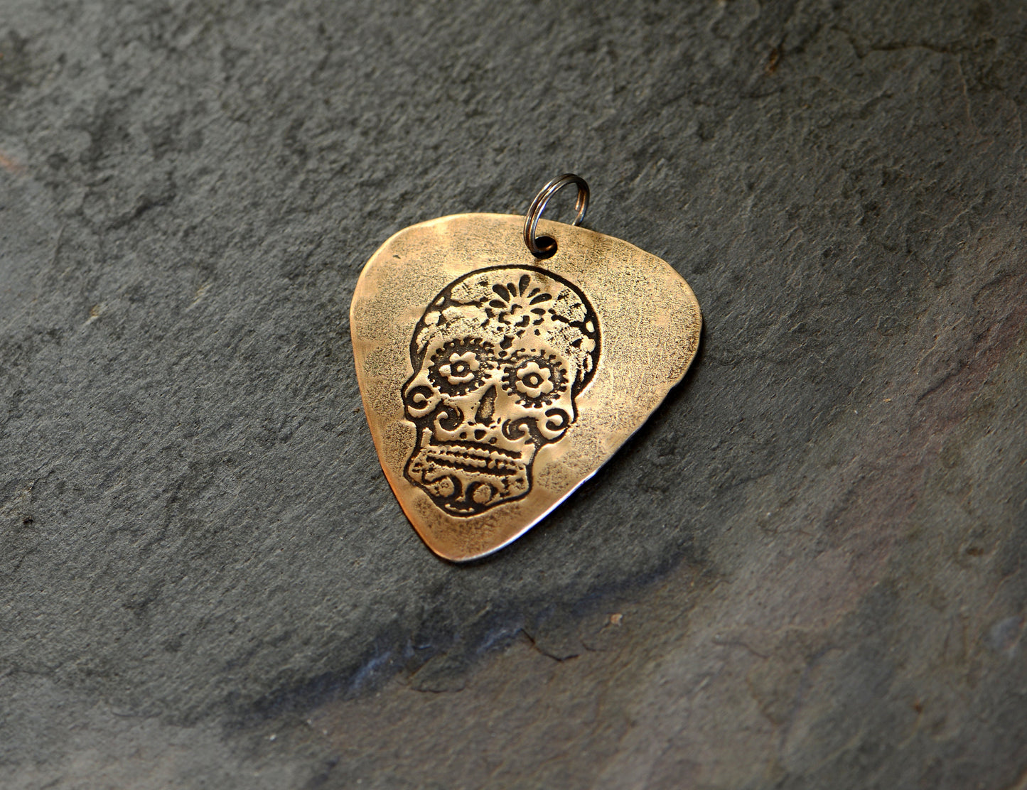Bronze guitar pick with sugar skull necklace