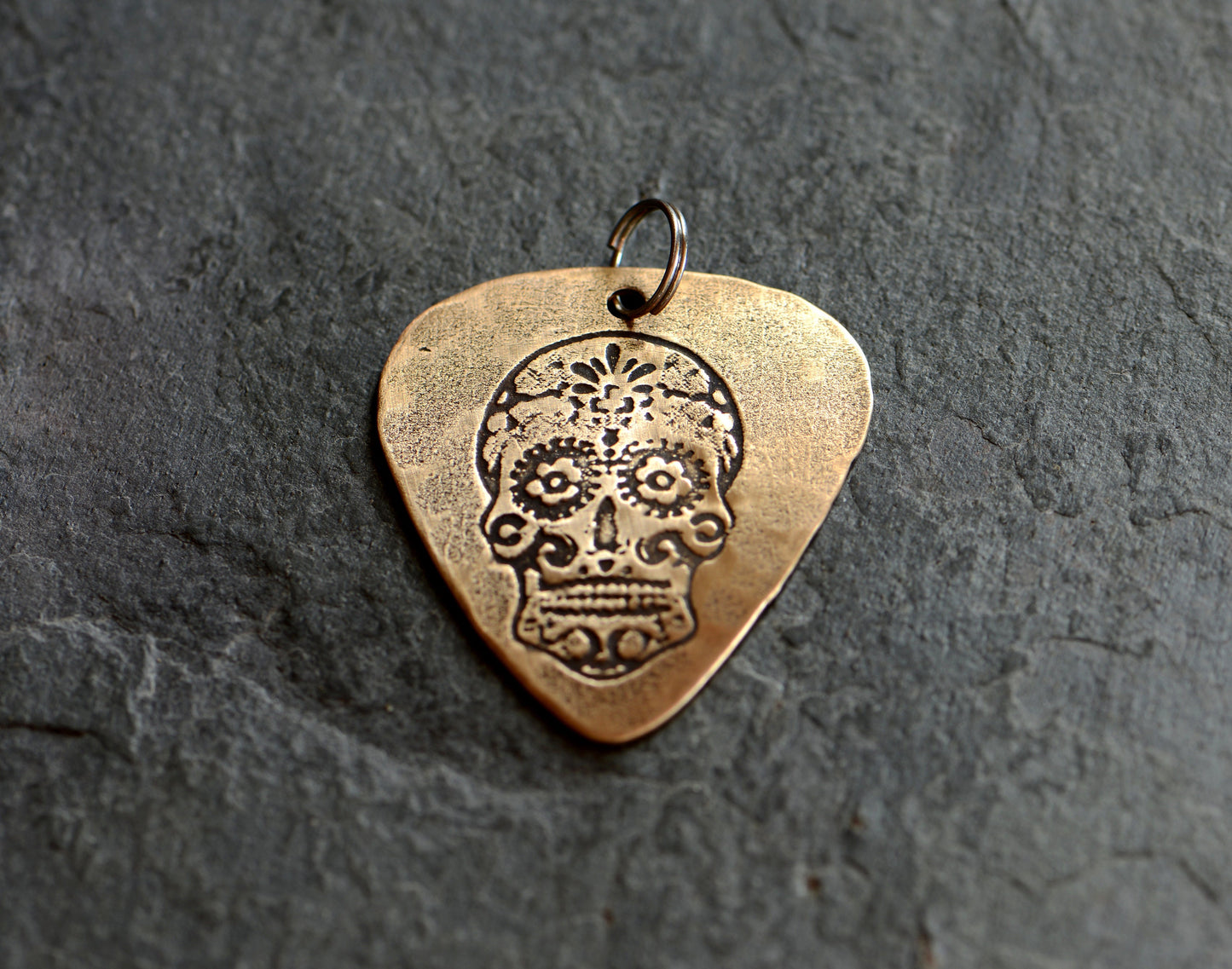 Bronze guitar pick with sugar skull necklace
