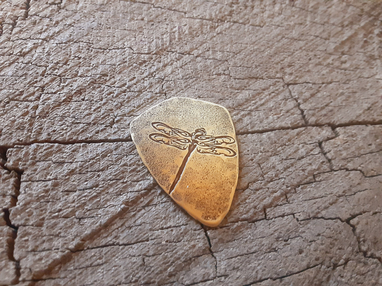 Playable brass guitar pick in shield shape with dragonfly