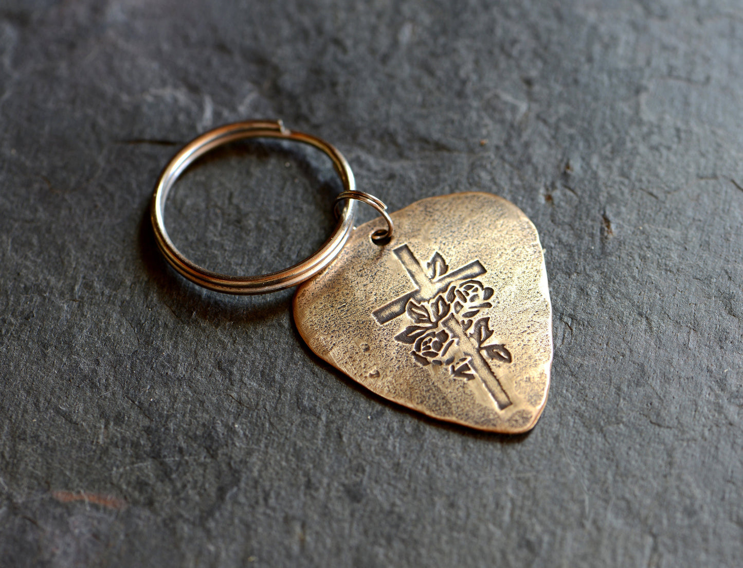 Roses and cross design on bronze guitar pick keychain