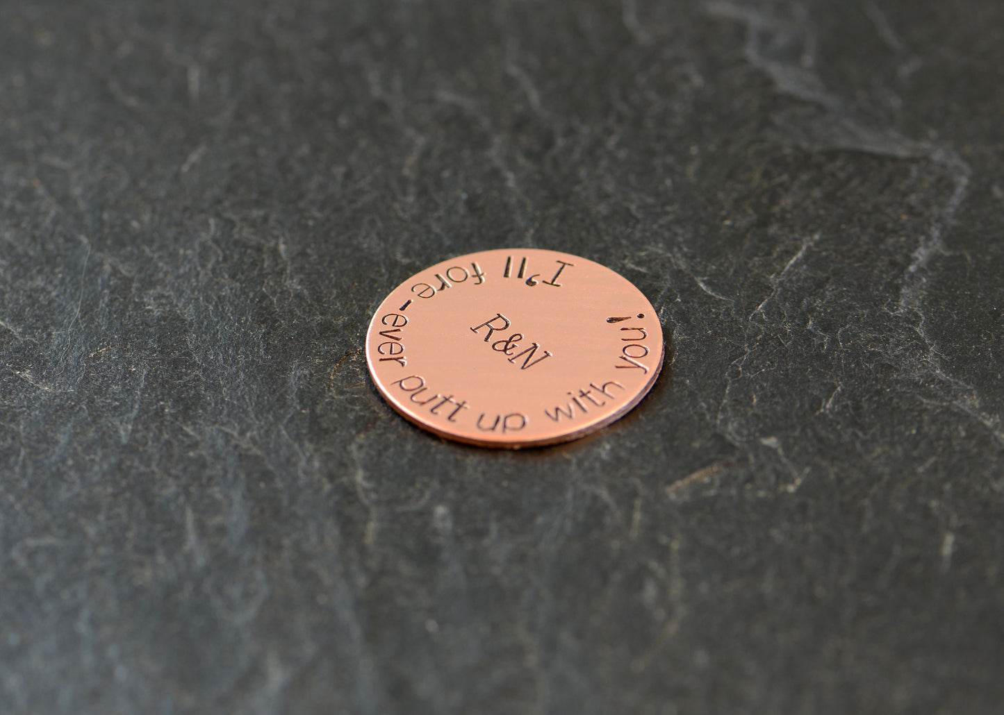 Initials on copper golf ball marker