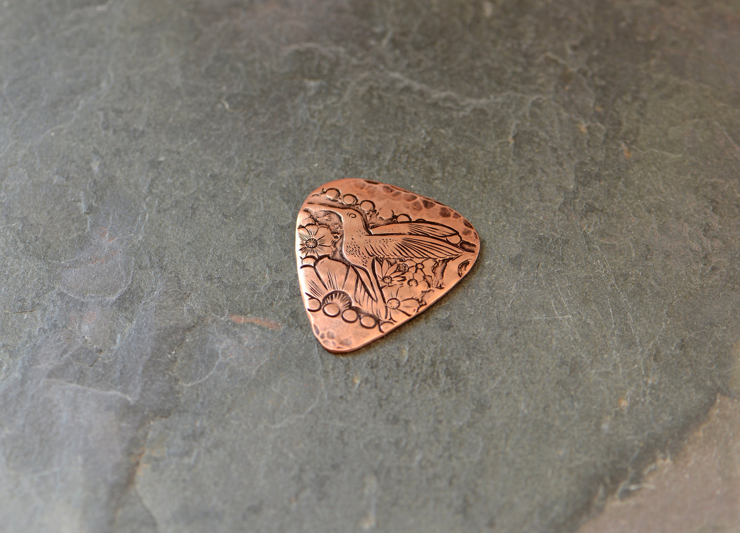 Guitar pick with hummingbird in copper