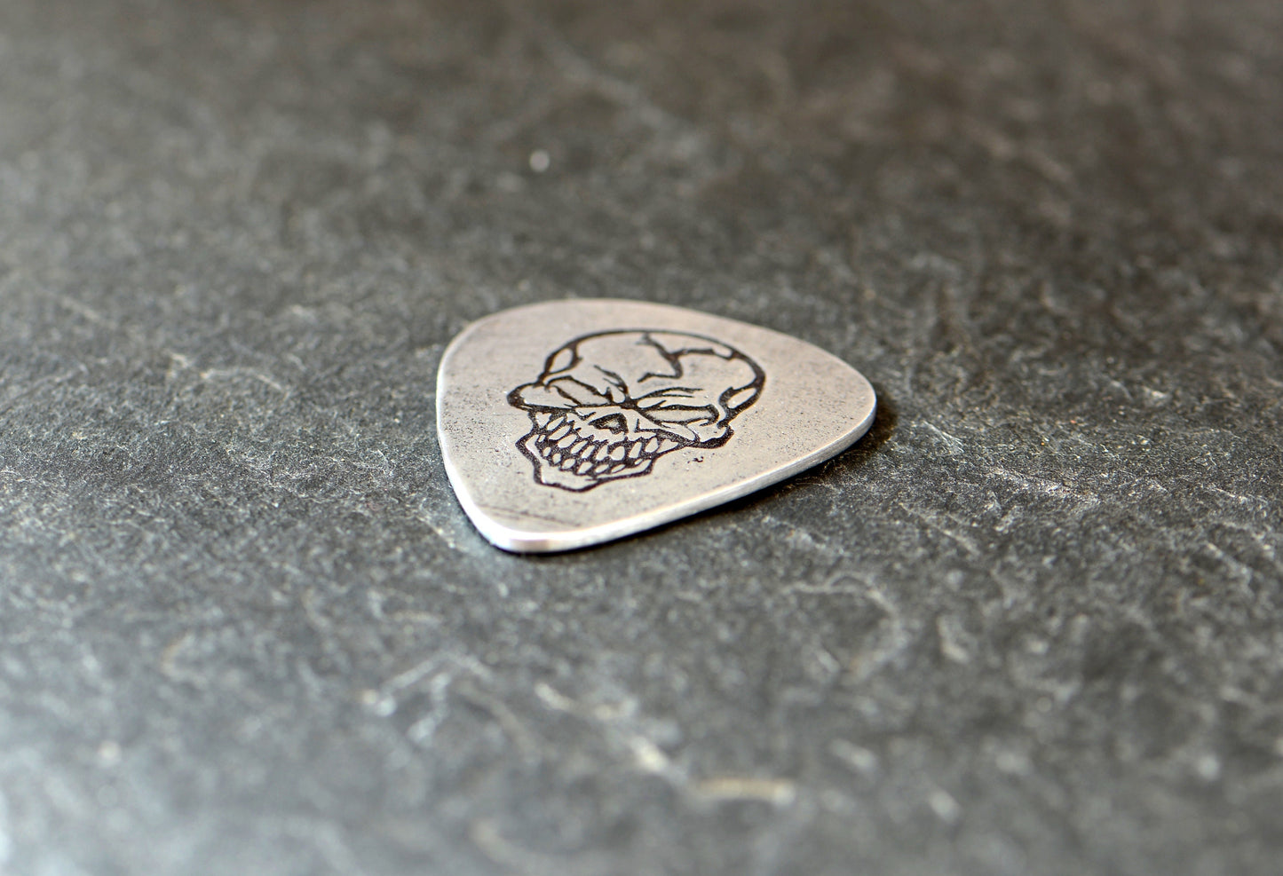 Sterling silver guitar pick with skull design