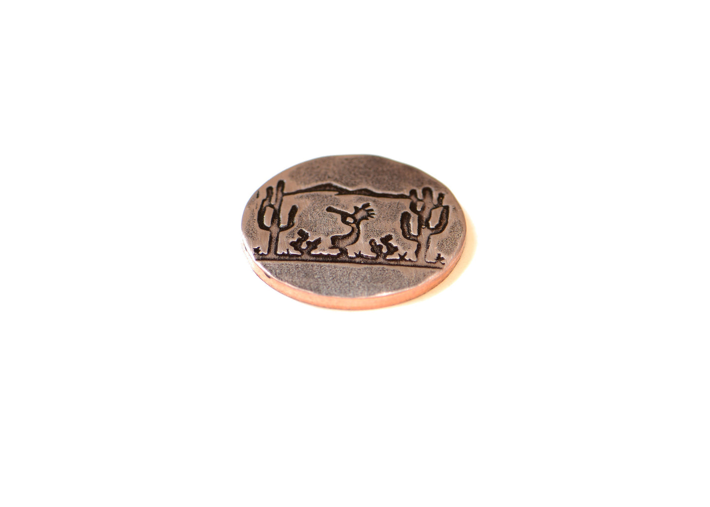 Golf ball marker with saguaro cacti and Kokopelli on copper
