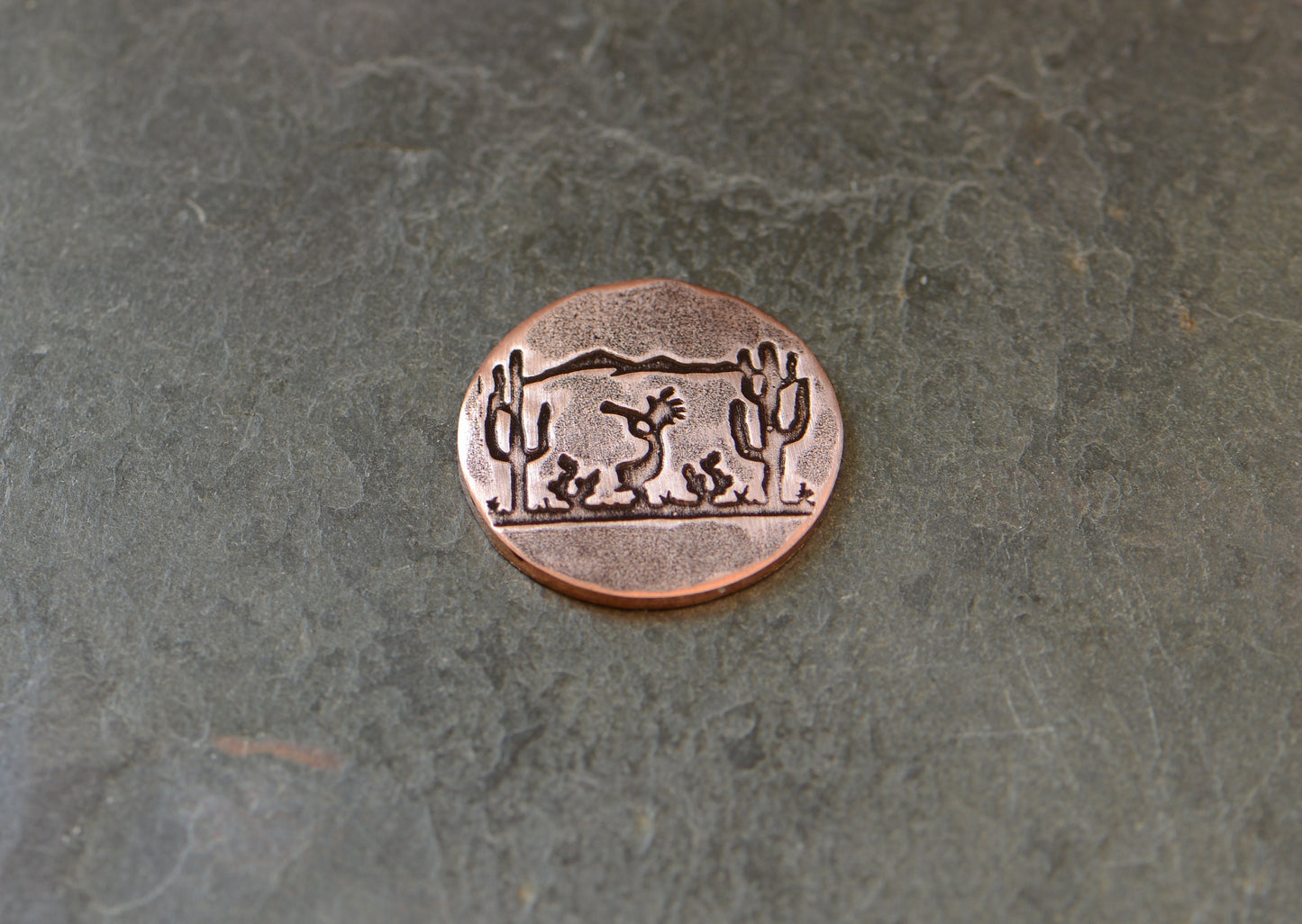Golf ball marker with saguaro cacti and Kokopelli on copper