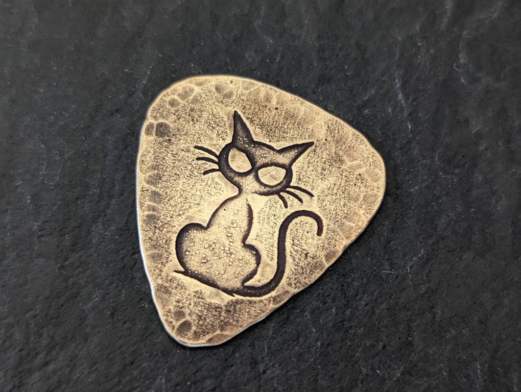 Cat on bronze guitar pick
