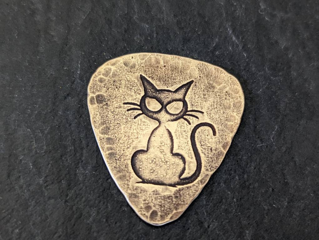 Cat on bronze guitar pick