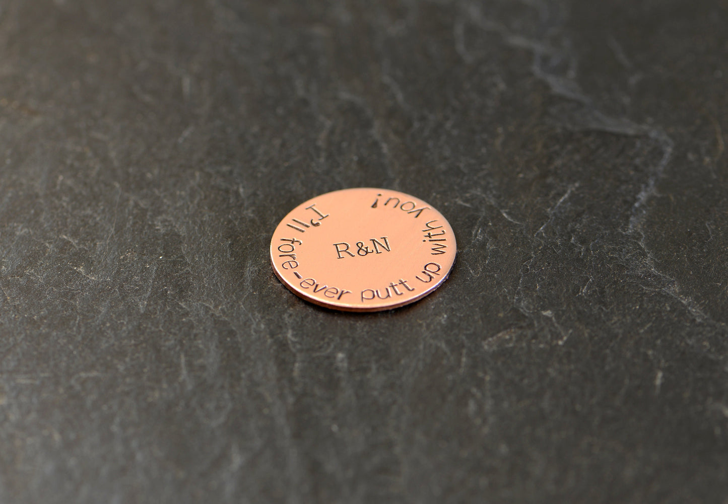 Initials on copper golf ball marker